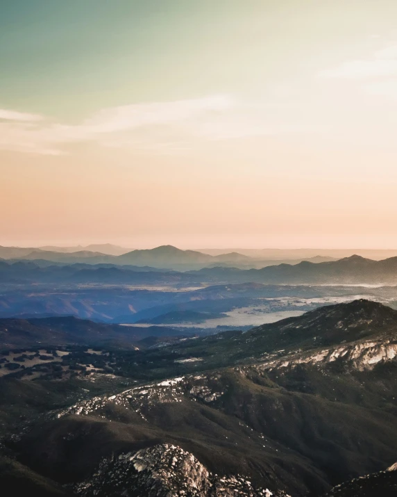 a plane flies above a scenic, mountainous area