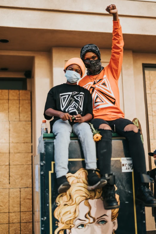 a woman and a man sit on top of an item