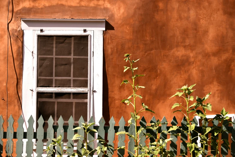 an orange building with a small white window