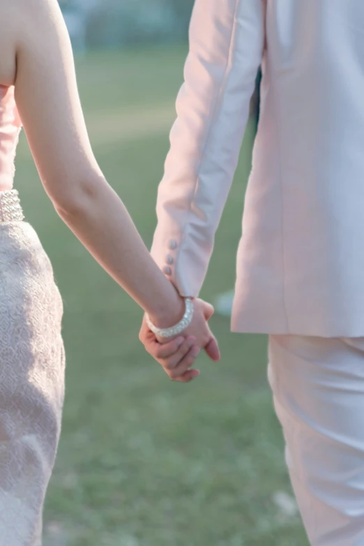 a close up of two people holding hands