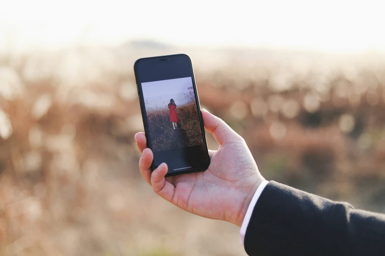 a person holding up an iphone with the image on it