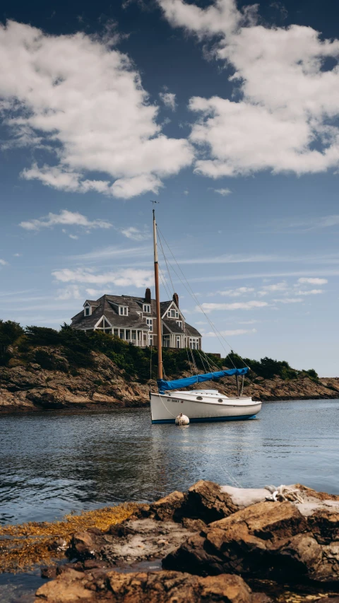 a white sail boat is in the middle of calm water