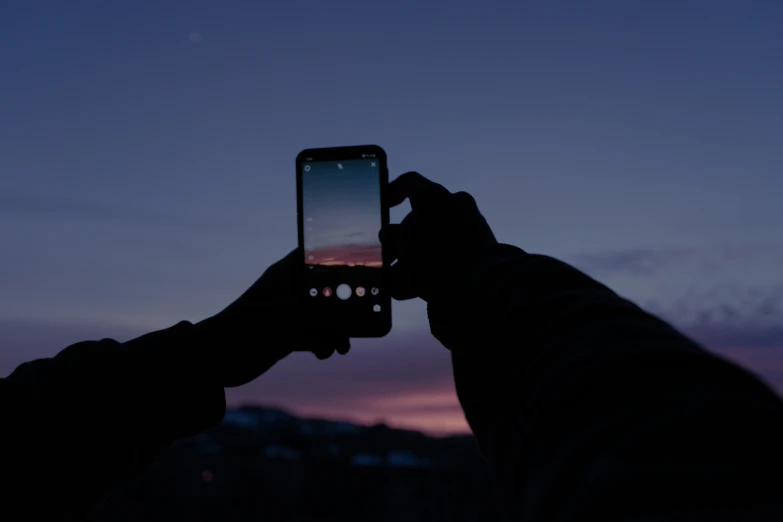 a person holding up a phone to take a picture