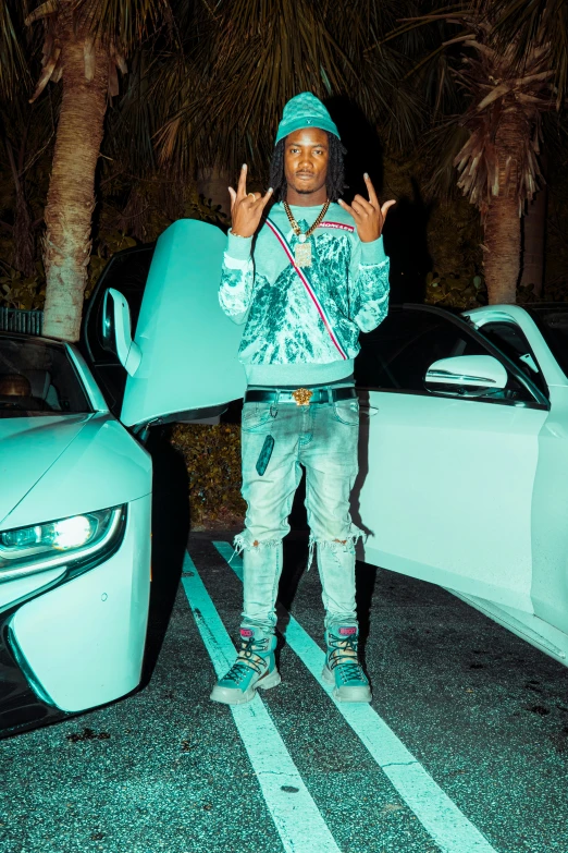 a man holding an oversized surfboard standing next to a car