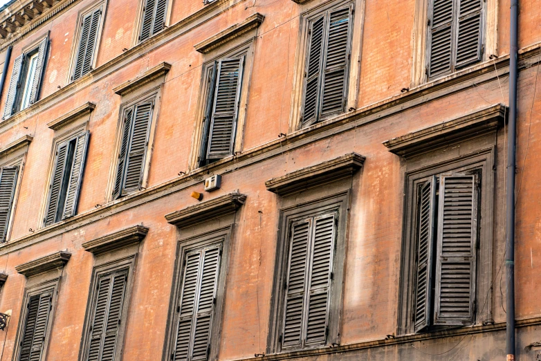 a building with windows filled with white and brown shutters