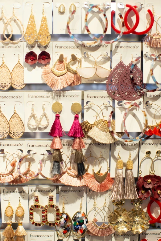 there are many earrings displayed on a wall