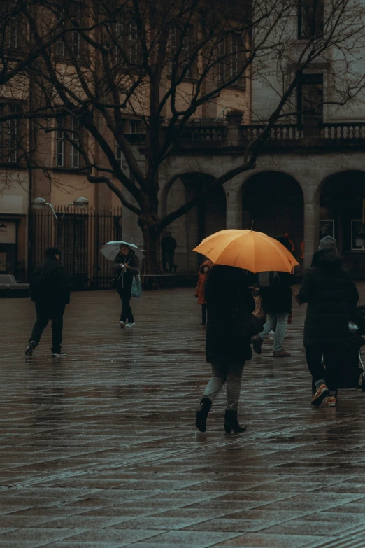 a group of people walking down the street holding umbrellas