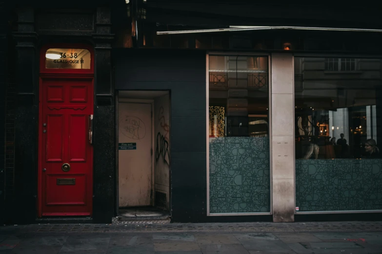 red doors sit outside the doorways of buildings