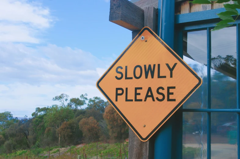 a slowy please sign hangs outside the window
