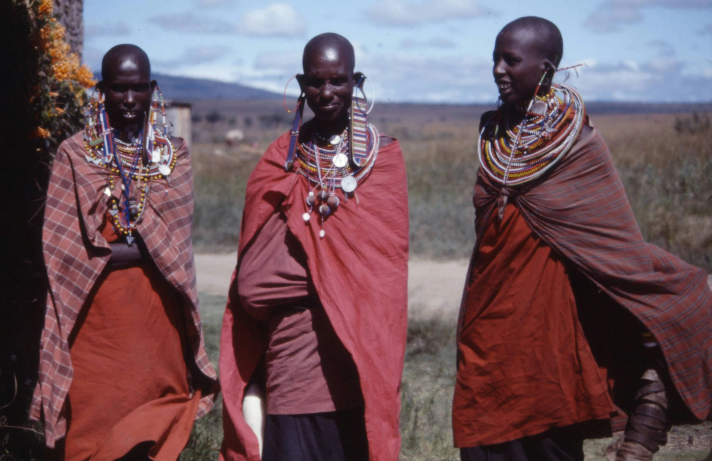 three people standing near each other holding some necklaces