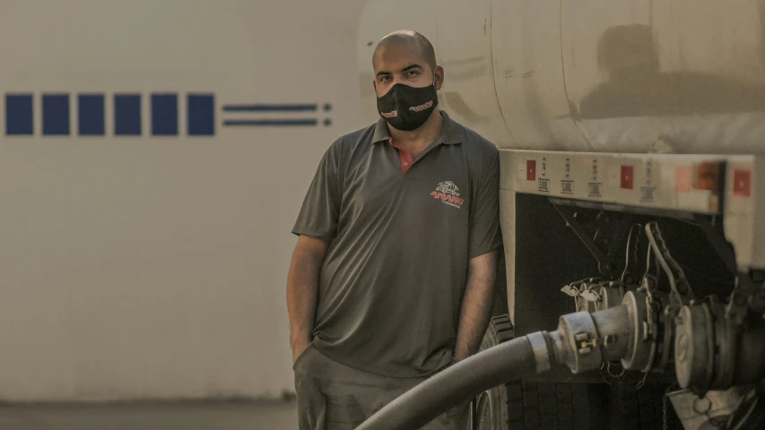 a man in a gas mask holding a hose