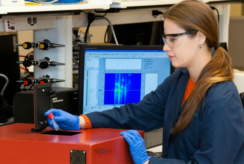 an image of woman with gloves on holding a monitor