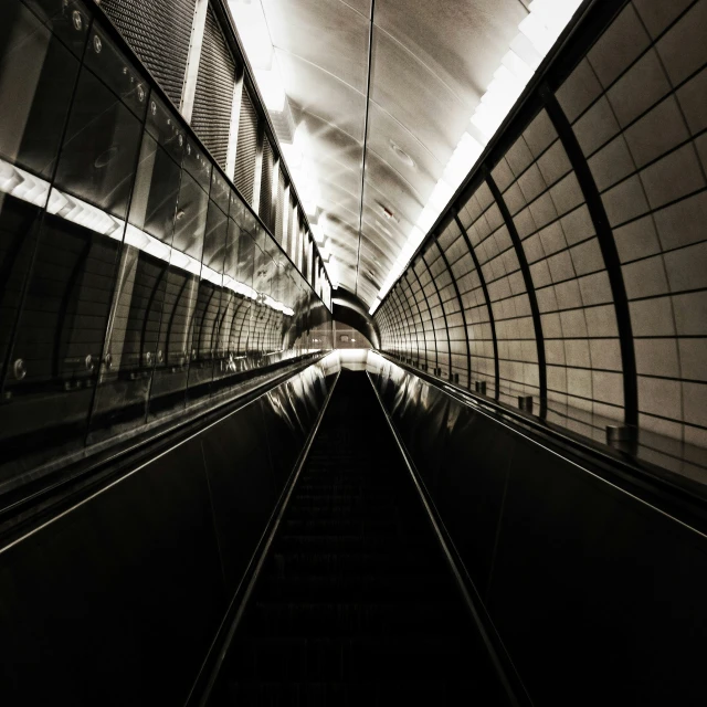 an empty escalator in the subway with only one way lines going