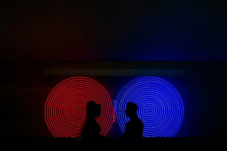 a couple of men standing in front of a light painting