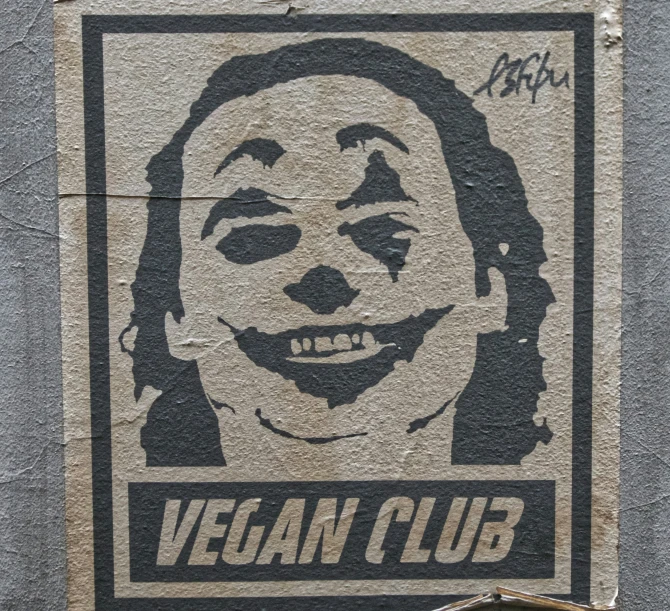 a graffiti on the side of a building, that has an image of a man in a face