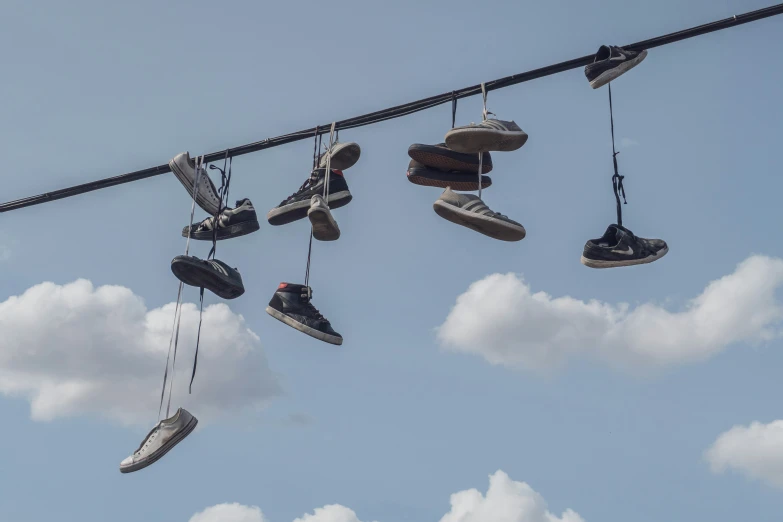 a couple of sneakers hang from a wire