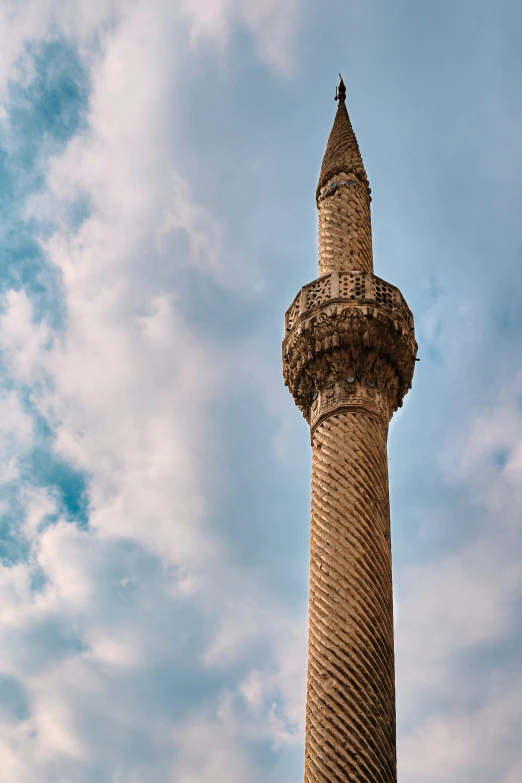 a large stone tower that is under some clouds