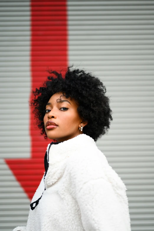 a woman is posing with a white coat