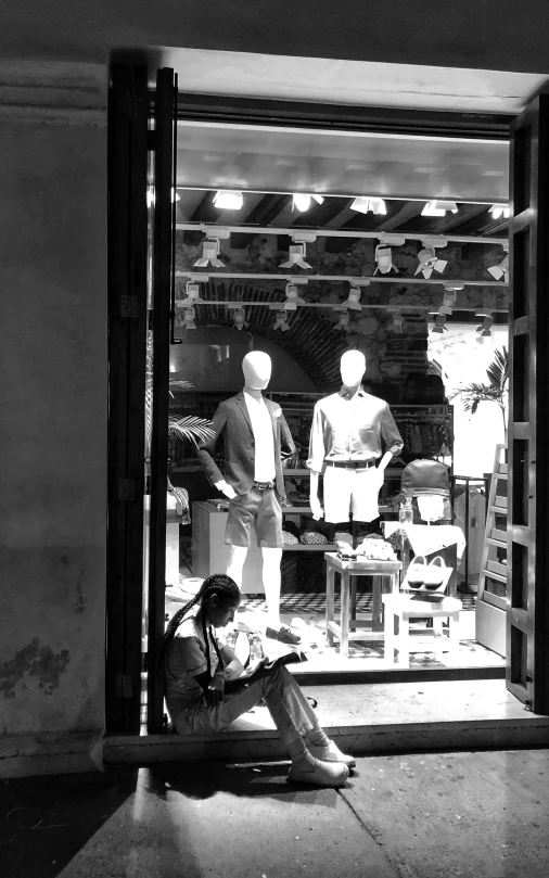 a man sitting on the floor near an open store