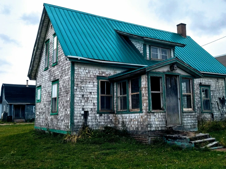 this house has a green tin roof and a stone