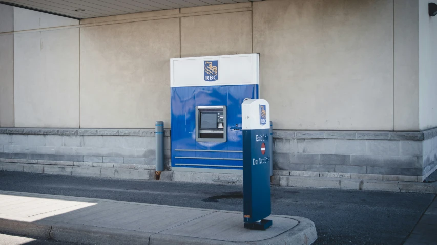 a blue and white atm machine is outside a building