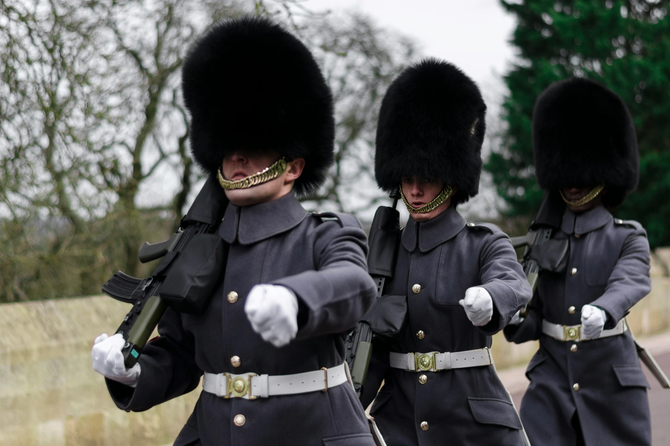 some uniformed men marching in the street with guns