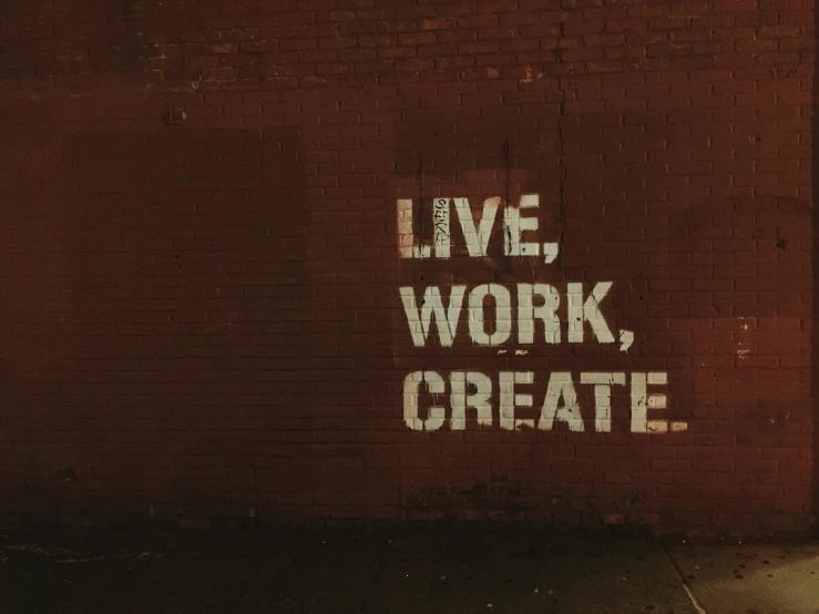 words painted on a brick wall with a stop sign beside it