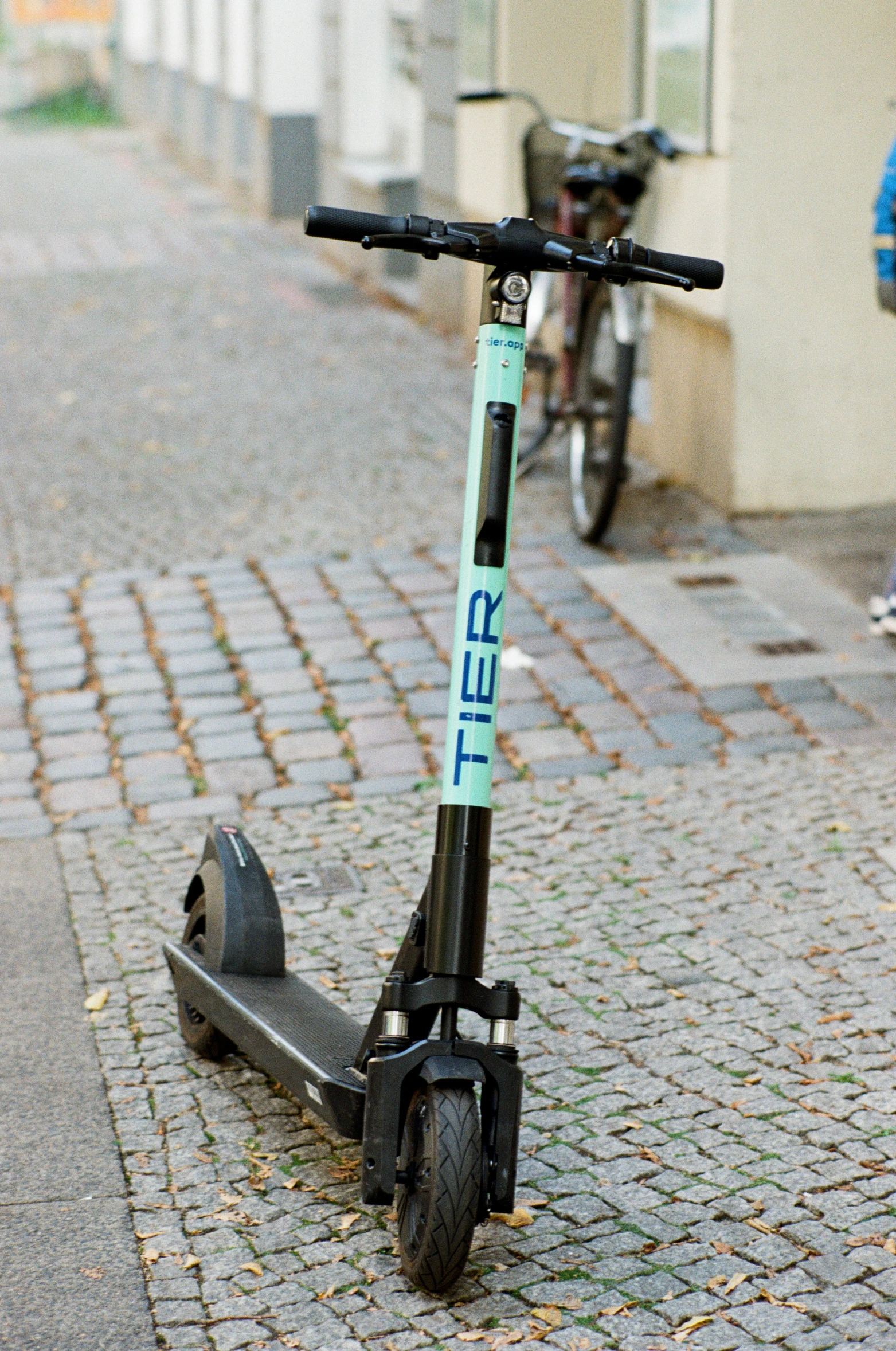 a bicycle parked on a street next to a scooter