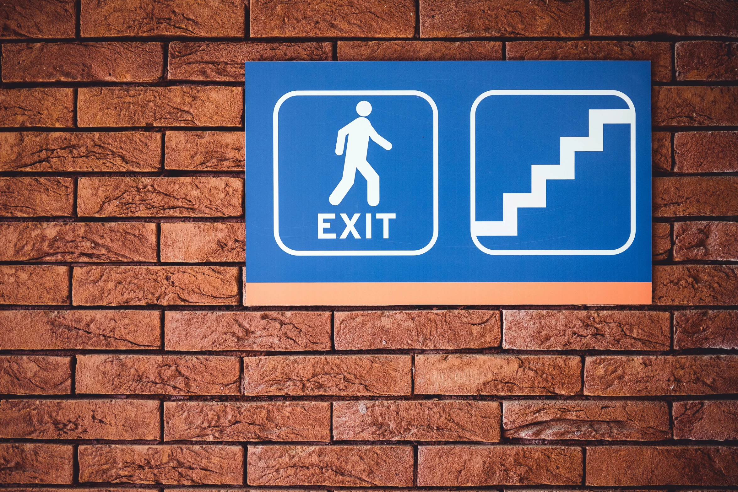 a blue sign and some bricks with the word exit