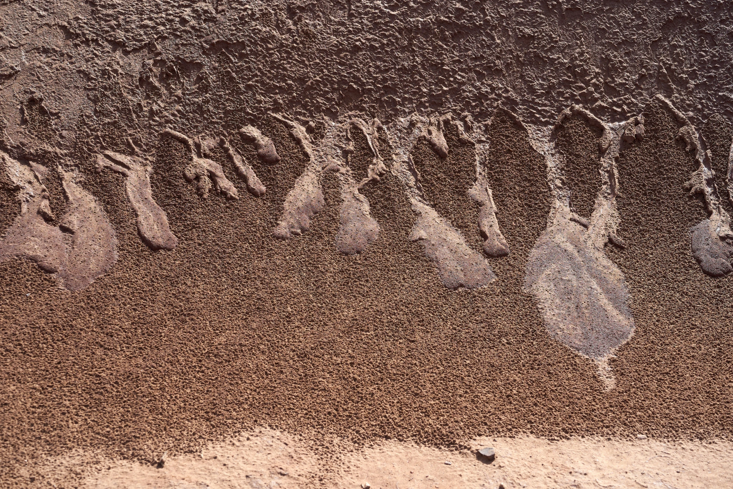 the letters are written on the sand near a beach