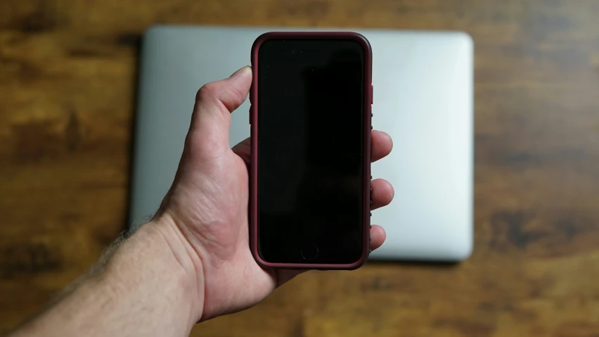 a person holding up a small cell phone