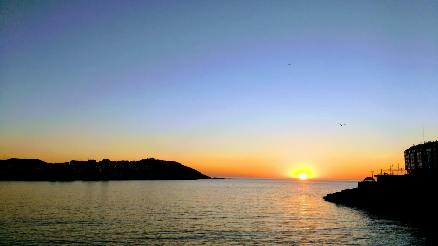 a picture of the setting sun and water