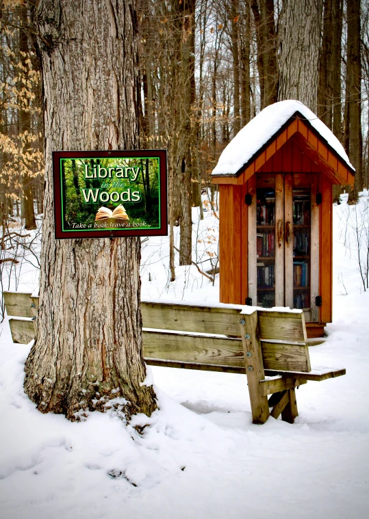 a sign attached to a tree in the snow