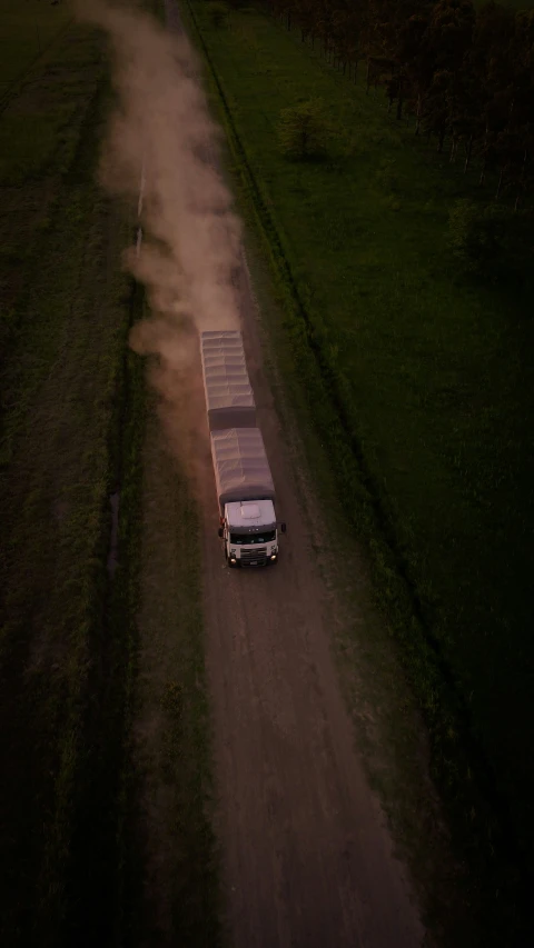 the truck is driving down the dusty road