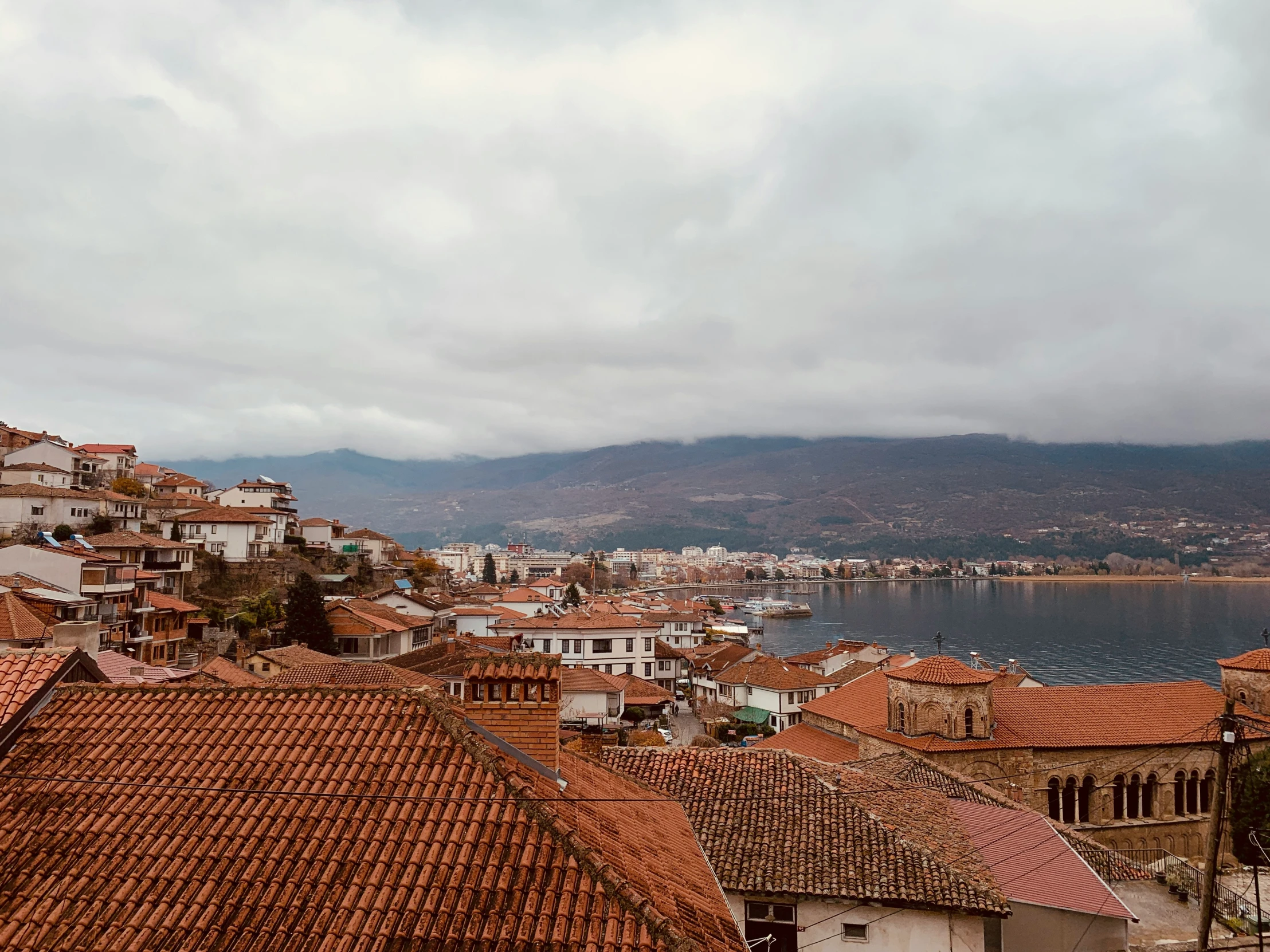 some buildings water and a hill and a mountain