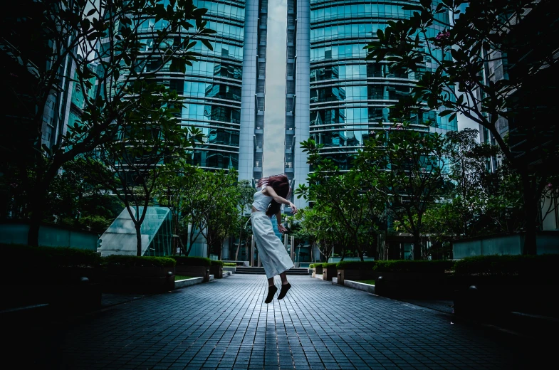 the woman is dancing in the city street near buildings