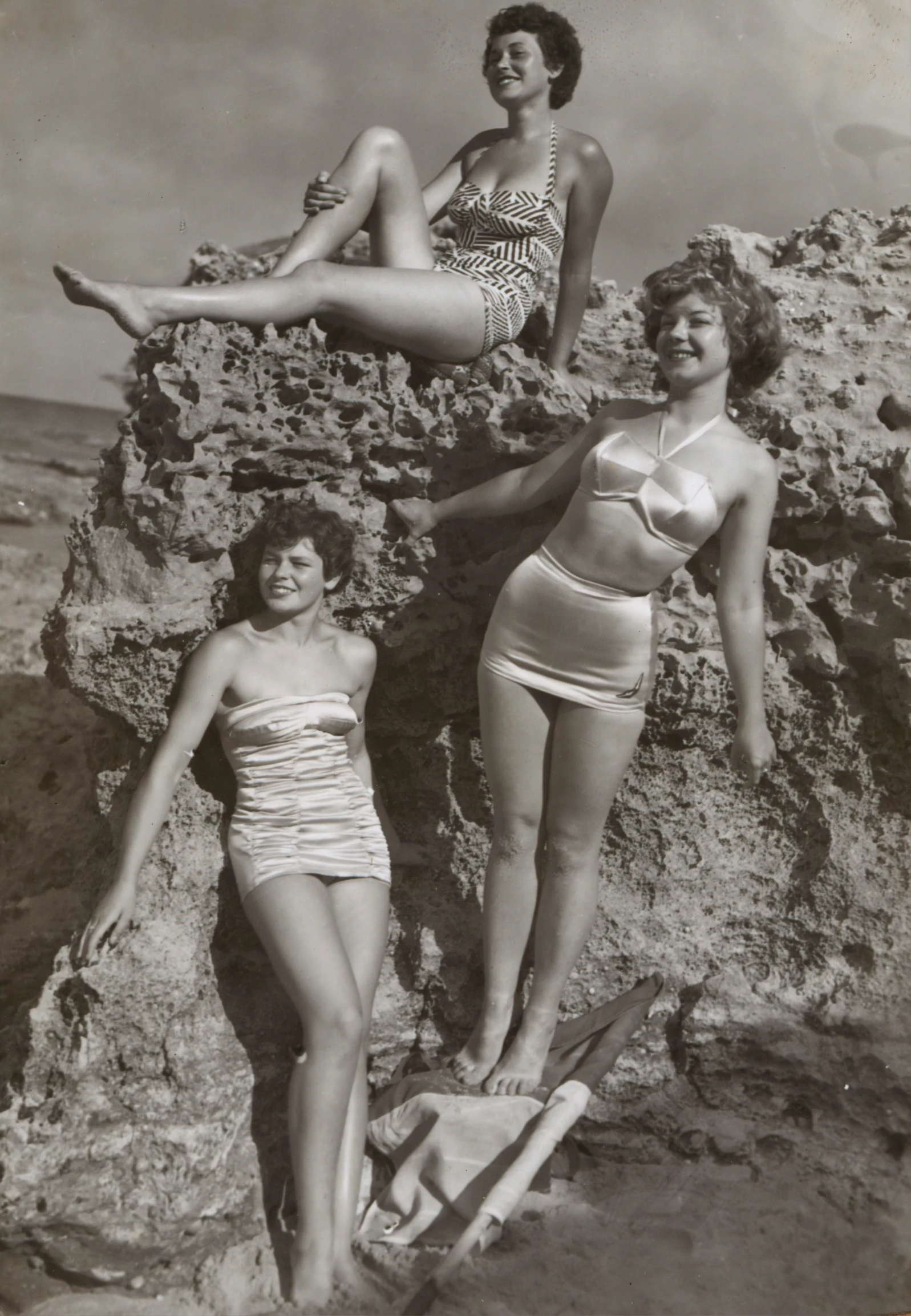 a group of ladies in bathing suits on a rocky ledge