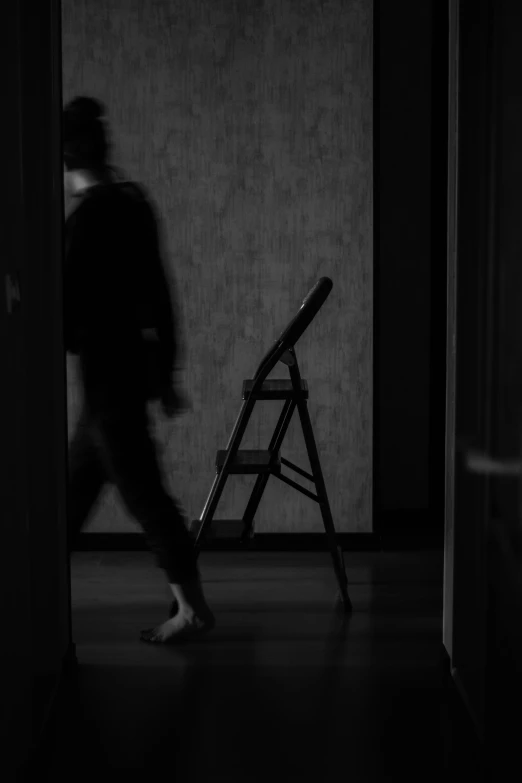 a young person is walking in the dark and stepping on a ladder