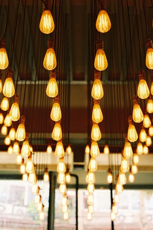 an array of light bulbs hanging from the ceiling in a building