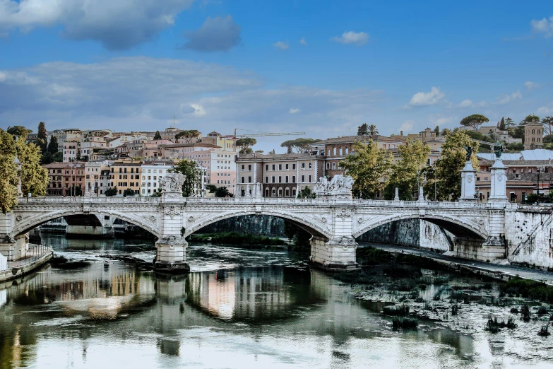 bridge with water flowing underneath and buildings with reflections on them