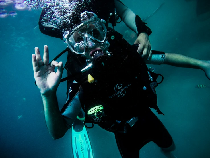 a man diving underwater with the help of a scuba instructor