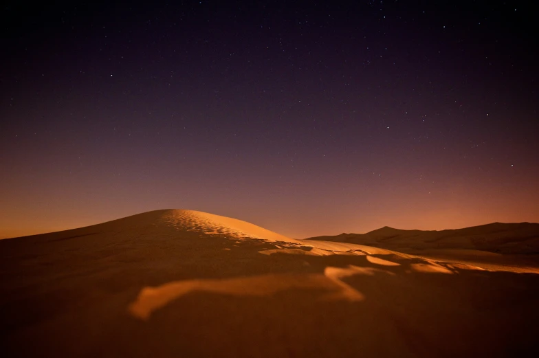 a desert landscape with a sky full of stars