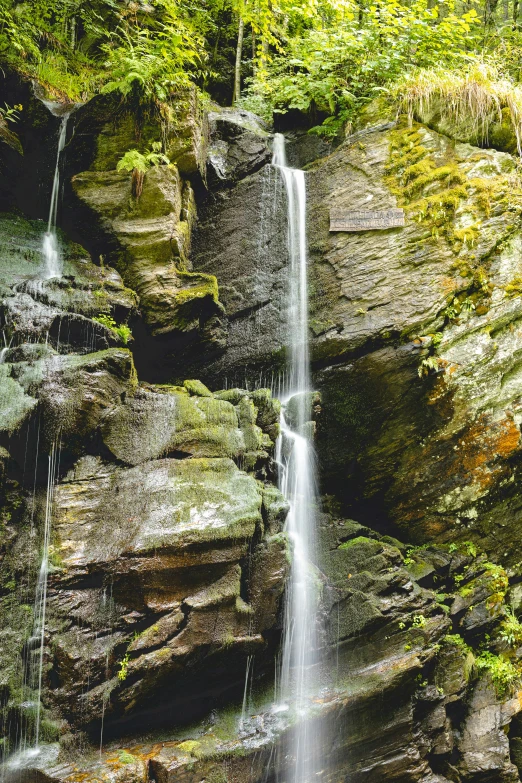 there is a waterfall next to some rocks