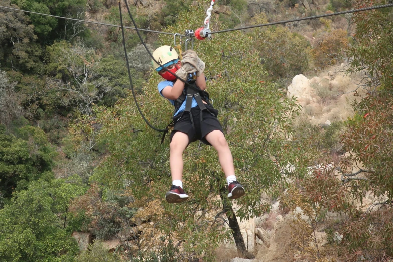 the man in the harness is about to go up the zipline