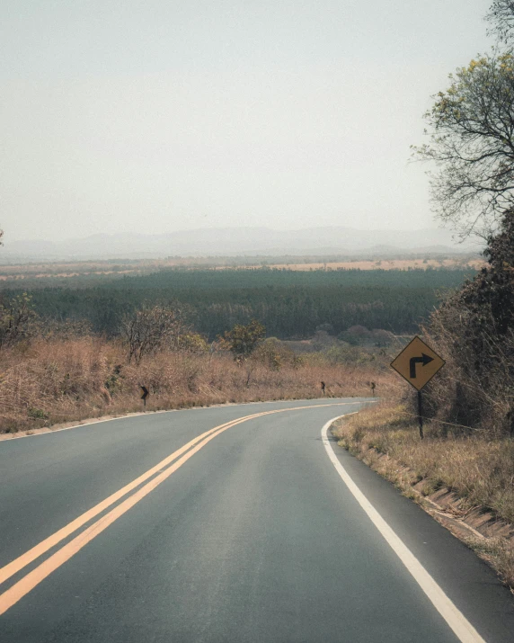 an empty rural road through a grassy plain