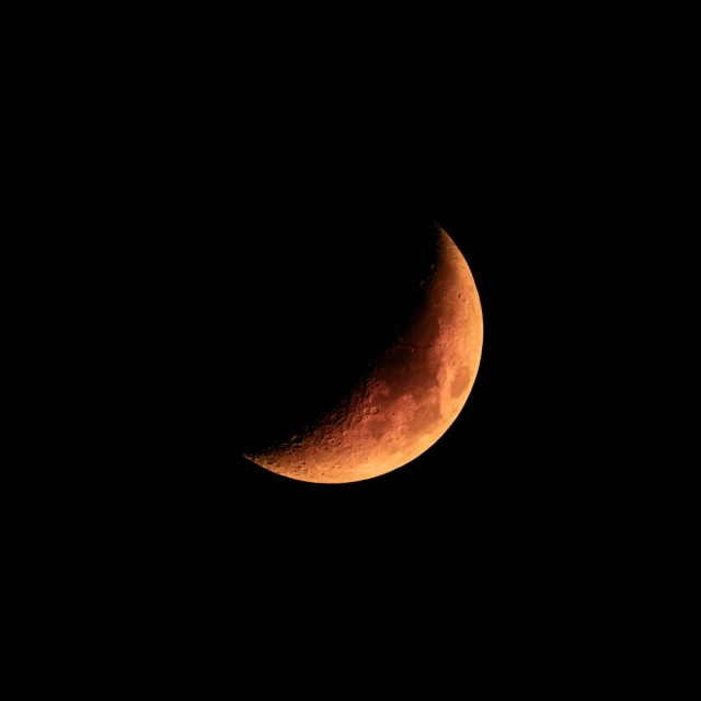 the crescent moon in the dark sky above