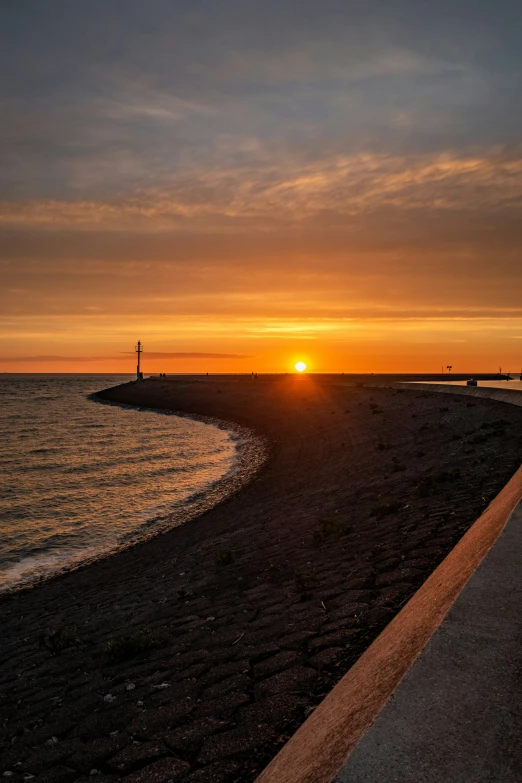 a sunset over a body of water with some rocks