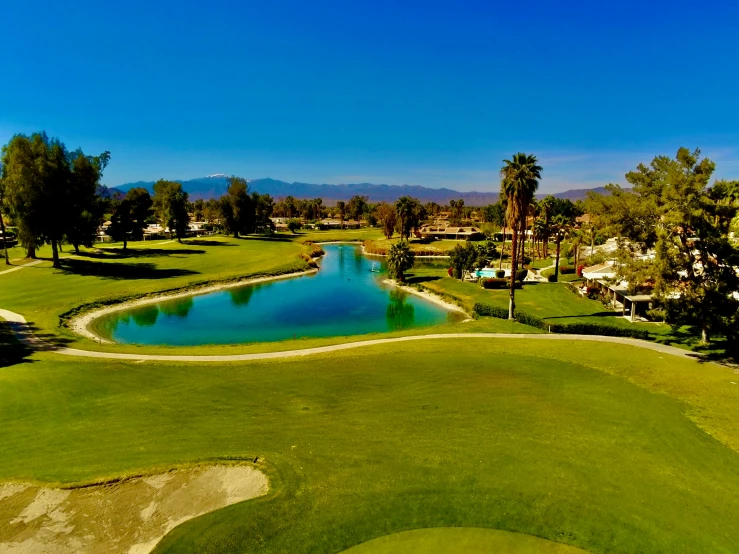 a golf course next to a body of water and several trees