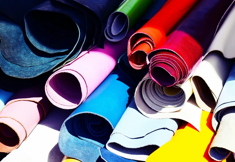 colored rolled up yoga mats stacked next to each other