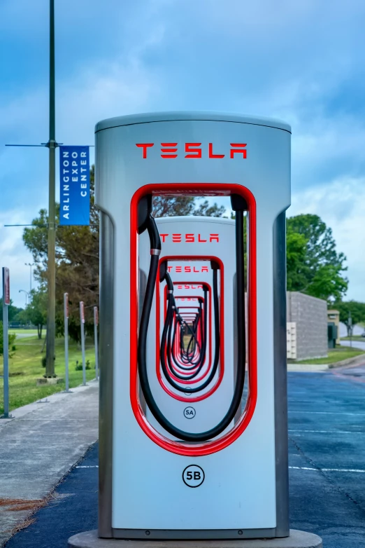 a white phone booth stands at the edge of the street